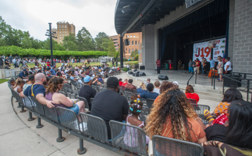 A group of people gather at an outdoor amphitheater for a Juneteenth celebration.